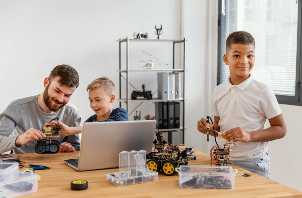 Pai com filhos construindo robô com um kit de robótica e programação