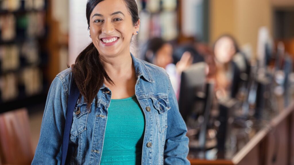 mulher de meia idade com estudantes mais jovens ao fundo em aprendizado
